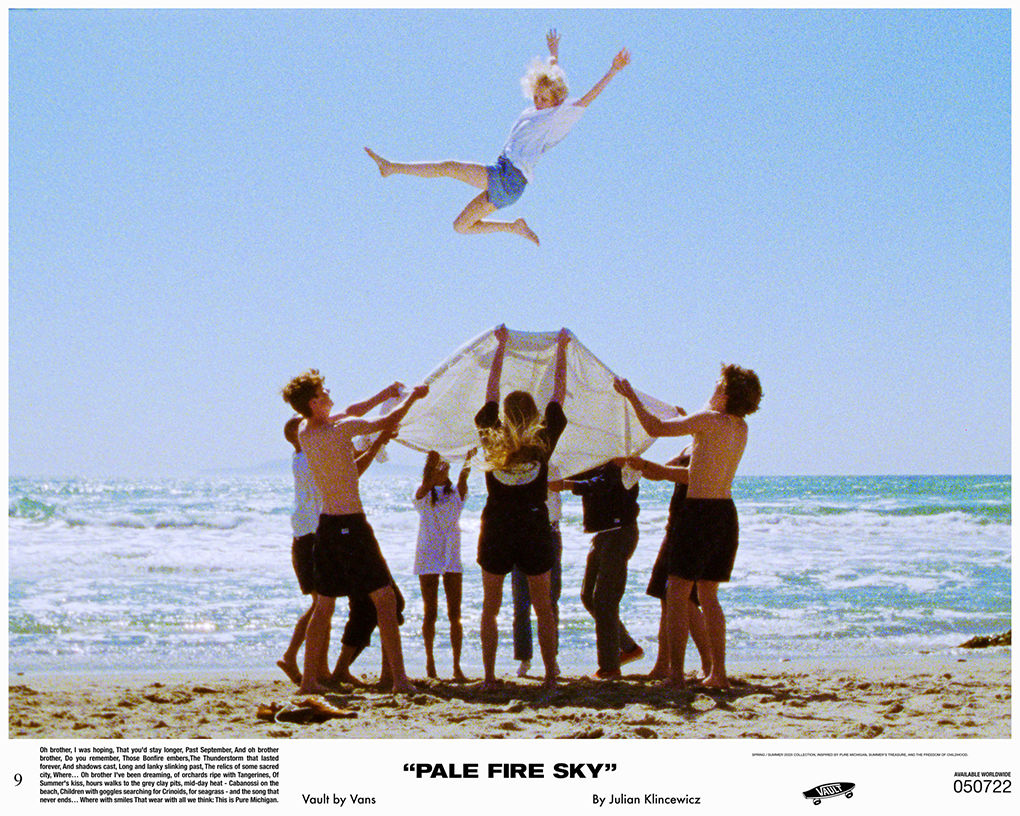 Group of people on beach using a sheet to toss another person in the air