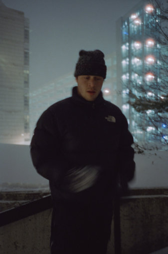 Cole Navin in winter gear against a snowy cityscape.