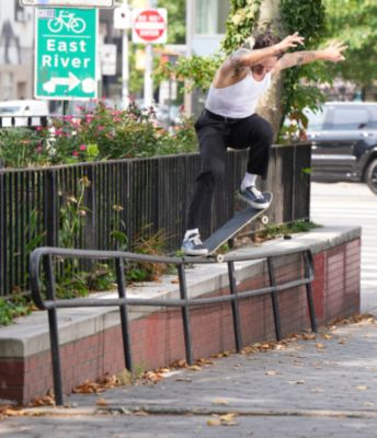 Elijah Berle riding a skateboard in an urban setting while wearing Vans shoes.