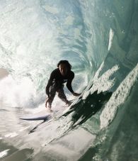 Vans surf time rider, Grant Noble, catching a wave in the ocean.