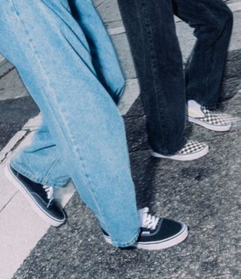 Vans black sk8 hi shoe, authentic shoe, old skool shoe and checkerboard slip on shoe laying outside on the cement.