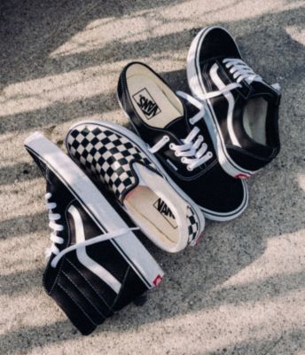 Vans black sk8 hi shoe, authentic shoe, old skool shoe and checkerboard slip on shoe laying outside on the cement.