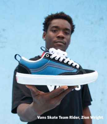 Vans skate team rider, Zion Wright wearing blue Skate Old Skool 36+ shoes while performing a skateboarding trick outdoors.