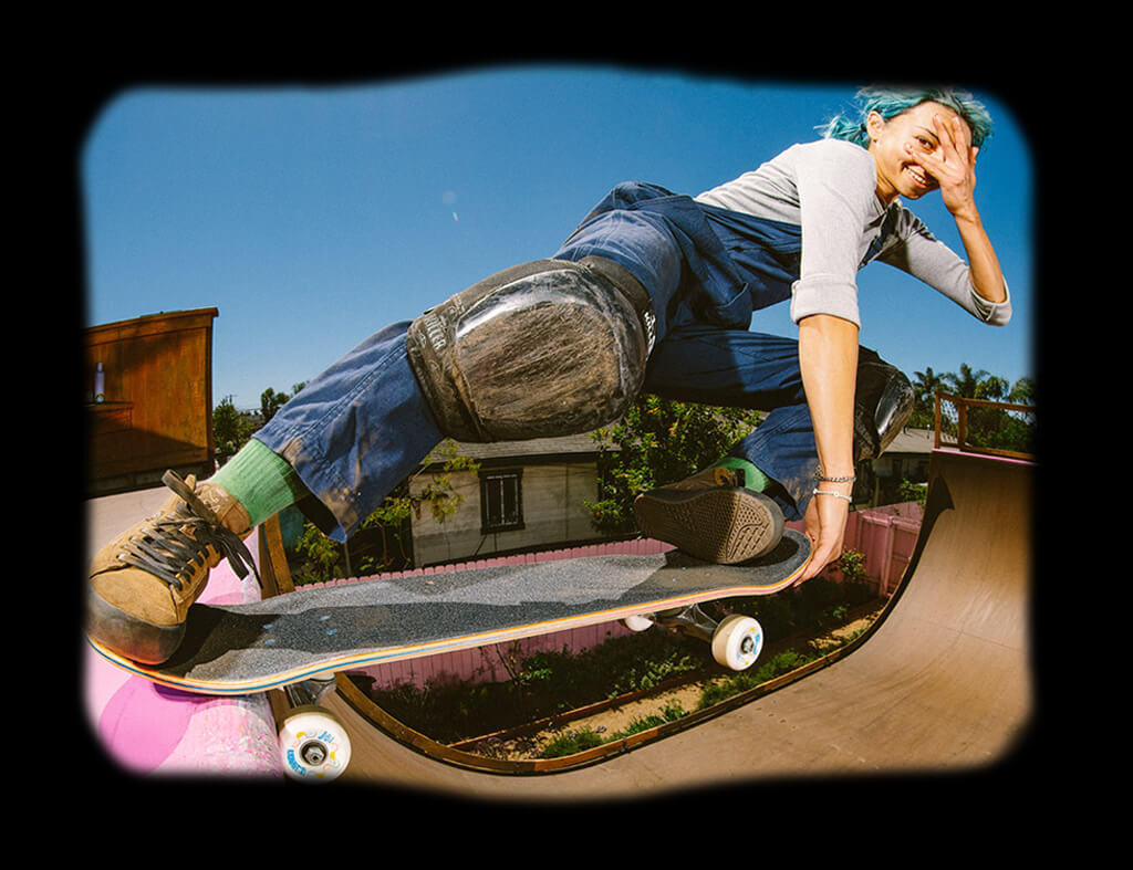 Lizzie Armanto wearing clothes from The Lizzie collection and posing on a skateboard at the top of a halfpipe.